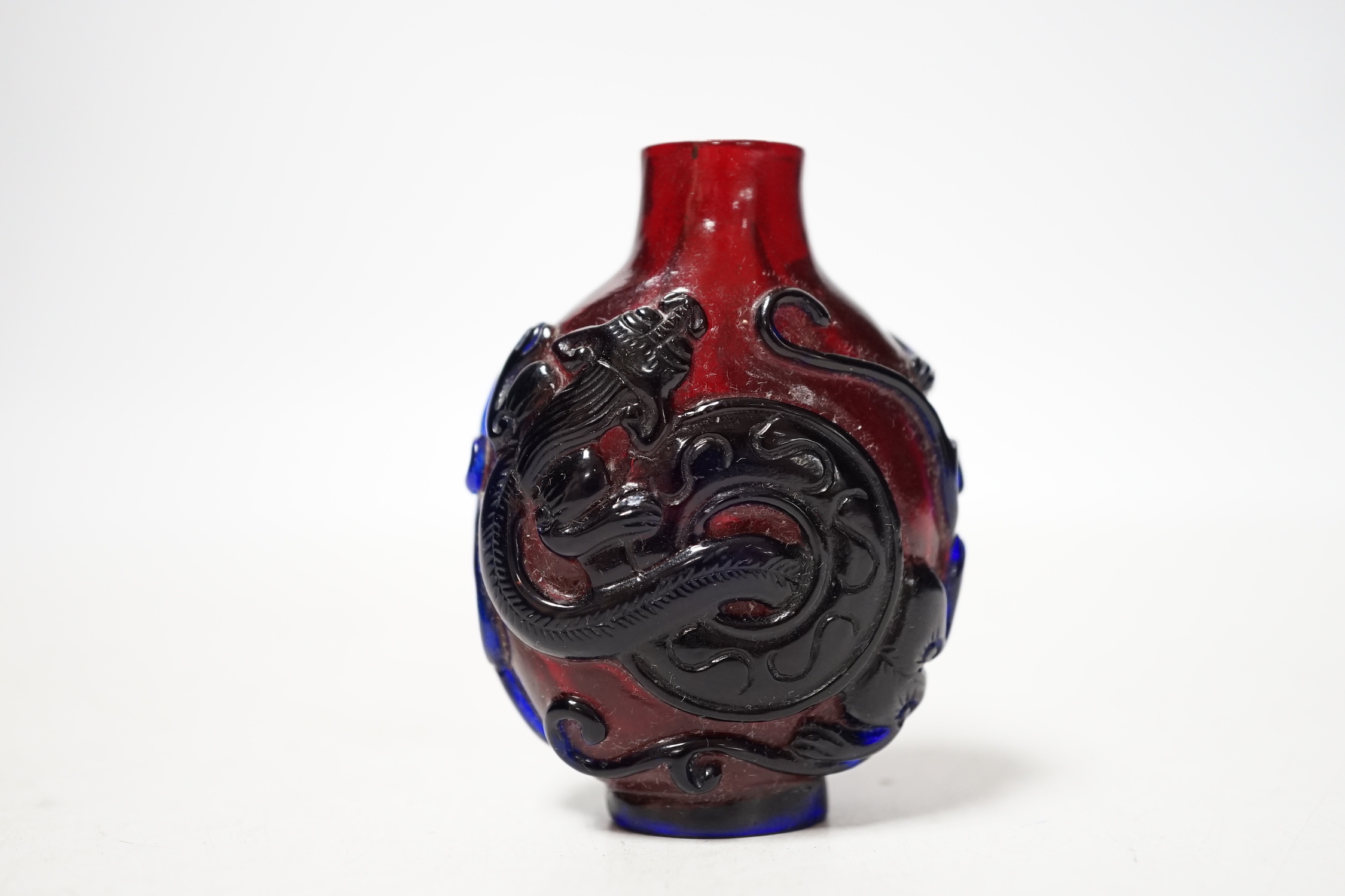 A Chinese amethyst and ruby glass ‘dragon’ snuff bottle, 19th century, 6cm high